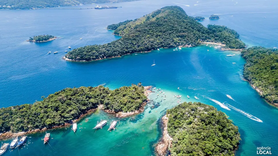 Escunas e lanchas em canal de água turquesa entre ilhas cobertas de mata - passeios de barco na Ilha Grande